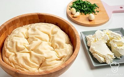 Замесите тесто. В теплое молоко добавьте соль и сахар. Туда же влейте растительное масло, перемешайте. В смесь добавьте муку, после чего замесите мягкое тесто. Затем накройте тесто пищевой пленкой и оставьте его в теплом месте примерно на 1 час. Когда оно поднимется в два раза, разомните его и оставьте подниматься еще раз.