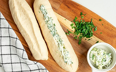 Испеките багет. Готовое тесто разделите на три равные части. Из них сформируйте батончики и дайте им постоять 20-30 минут. После этого с помощью вилки сделайте небольшое углубление вдоль по всему тесту. Смажьте его подготовленной зеленью с маслом и чесноком. Поверхность теста помажьте растительным маслом и посыпьте тертым сыром. Поставьте багеты выпекаться при 190 градусах до румяного цвета на 15-20 минут.