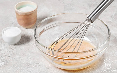 Разбейте в миску яйца. Посолите, всыпьте сахар. Хорошо взбейте массу венчиком до полного растворения сахара и соли.