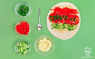 Сформируйте рулетики. Лаваш расстелите на поверхности. Смажьте творожно-горчичной пастой. Затем разложите в произвольном порядке помидоры, огурцы и перец. Посыпьте измельченным укропом. Сверните рулет, заверните его в пищевую пленку и отправьте в холодильник для пропитки минимум на 10-15 минут.