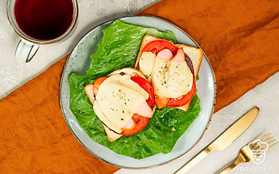 Застелите плоскую сервировочную тарелку листьями салата, выложите тосты с кетчупом, оформите свежей зеленью.