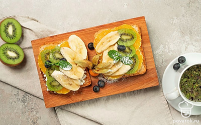 Из кусочков фруктов вырежьте цветы и любые красивые фигурки. Украсьте тосты листочками мяты.