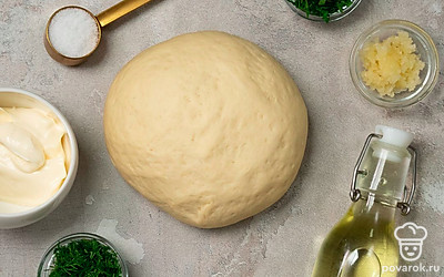 Приготовьте тесто. В глубокую миску вылейте воду, добавьте дрожжи и сахар, перемешайте и оставьте на 10 минут. Спустя время влейте подсолнечное масло, добавьте соль и понемногу всыпайте муку. Вымешивайте тесто до полной однородности примерно 15-20 минут. Тесто выложите в миску, накройте полотенцем и оставьте для подъема в теплом месте на 60 минут.