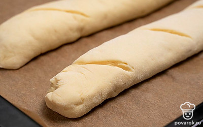 Сформируйте багет. Раскатайте готовое тесто в прямоугольный пласт толщиной 3-5 мм. Сверните пласт теста в рулет, закрепите края. На противень выложите багет швом вниз, разметьте ножом места поперечных надрезов и оставьте багет для расстойки в теплом месте на 20 минут. Выпекайте багет в духовке при 180 градусах в течение 20 минут.