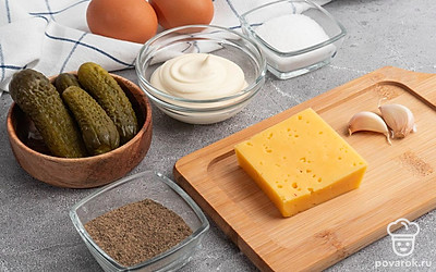 Убедитесь, что у вас есть все продукты в нужном количестве. Отварите куриное яйцо заранее, почистите чеснок, слейте рассол у огурцов.