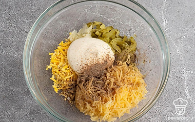 Смешайте вместе в отдельной посуде майонез, соль, перец, огурец, сыр, желток и чеснок до густой массы.