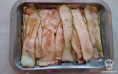 Кабачки нарежьте тонкими ломтиками, посолите их по вкусу и оставьте на 5 минут. Разогреть сковородку, Налейте в нее оливковое масло и обжаривайте тонкие ломтики кабачков с каждой стороны по 1 минуте, до румяной корочки.