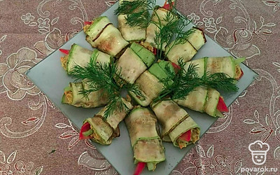 Выложите все рулетики из кабачков на большое блюдо. Украсьте блюдо укропом или посыпьте кунжутом. Поддавайте к столу как закуску.