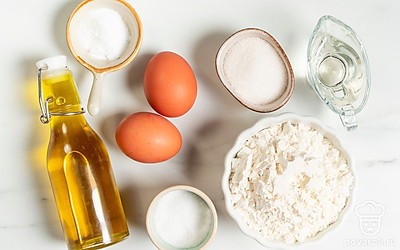 Согрейте воду до температуры чуть выше комнатной. Вымойте и обсушите яйца. Просейте муку в миску, где планируете замешивать тесто. Приготовьте широкую плоскую сковороду и блюдо для подачи оладушек.