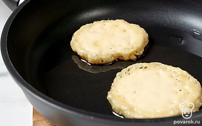 Немного убавьте огонь и жарьте оладушки с одной стороны до румяной корочки около 3-4 минут