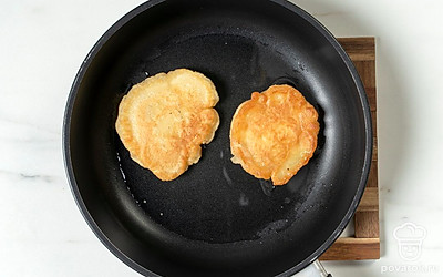 Переверните плоской лопаткой и жарьте еще столько же, пока оладушки не подрумянятся.