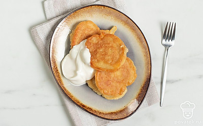 Подавайте горячие оладушки со свежей сметаной.