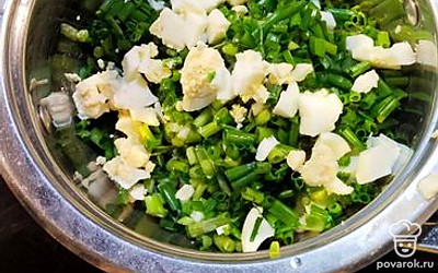 В миску нарезаем отварные яйца и зеленый лук.