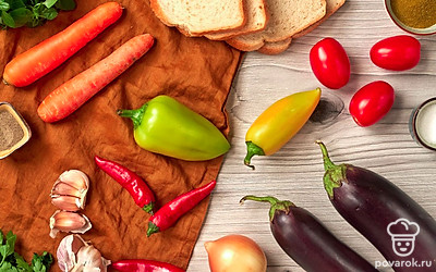 Овощи и зелень вымойте в прохладной воде и обсушите бумажными полотенцами. У болгарского и острого перца удалите плодоножку, семена и перегородки. Лук и чеснок очистите от шелухи. У баклажанов и помидоров вырежьте плодоножку, а морковь очистите от кожицы. Лук нарежьте маленькими кубиками. Морковь нарежьте кружочками по 0,3-0,5 см толщиной. Болгарский и стручковый перец нарежьте небольшими кубиками. Подсушите в тостере хлеб.