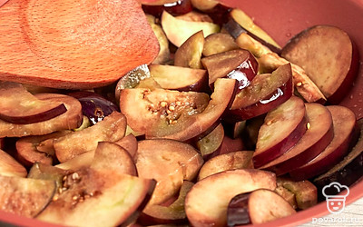 Подготовьте баклажаны. Баклажаны нарежьте полукольцами толщиной 6-7 мм, посыпьте 3 ст. л. соли и хорошо перемешайте. Оставьте баклажаны на 30 минут, затем промойте под проточной водой от соли и хорошо отожмите. На сковороде разогрейте растительное масло и обжарьте баклажаны в течение 15 минут, периодически помешивая, чтобы они стали мягкими, но не разварились.