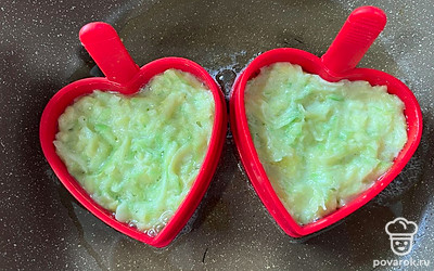 Установить силиконовые формы и разложить в них кабачковое тесто. Жарить 5-7 минут на медленном огне.