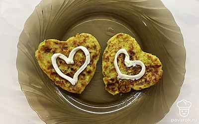 Украсить оладьи можно сердечками, нарисованными сметаной. Она отлично сочетается с кабачком.