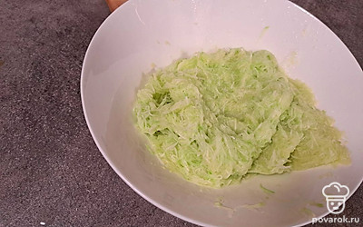 Трем кабачок на мелкой терке и отжимаем жидкость, которая успела выделится из кабачка.