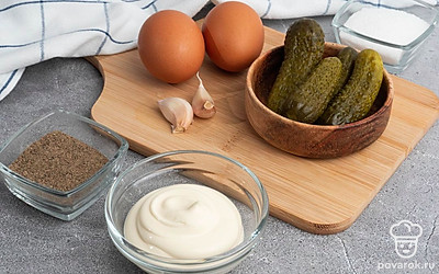 Убедитесь, что у вас есть все продукты в нужном количестве. Отварите куриное яйцо заранее, слейте рассол у огурцов, почистите чеснок.
