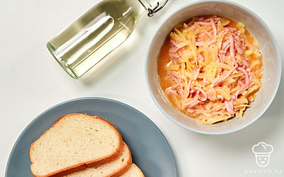 Сделайте начинку. Натрите сосиски на крупной терке, добавьте их к картофельной массе, тщательно перемешайте. Яйца взбейте, отправьте в миску. Тщательно перемешайте.