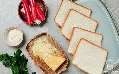 Крабовые палочки освободите от упаковки, разморозьте, мелко нарежьте. Сыр натрите на мелкой терке. Петрушку промойте, просушите и мелко порубите, оставьте две веточки для подачи. Разогрейте сковороду.