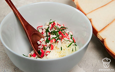 Подготовьте тосты к тепловой обработке. Соедините измельченные крабовые палочки, тертый сыр и рубленую петрушку, заправьте майонезом и тщательно перемешайте. На два ломтика хлеба распределите начинку, прикройте оставшимся хлебом и слегка прижмите.