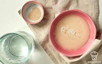 Приготовьте опару. Сухие дрожжи и теплую воду смешайте в небольшой мисочке, уберите в теплое место и накройте полотенцем. Оставьте дрожжи на 10-15 минут, чтобы поднялась шапочка.