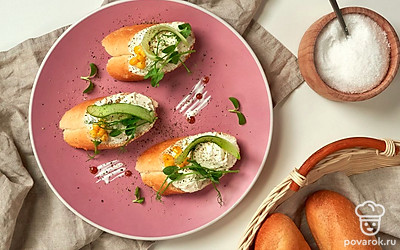 Багеты нарежьте на кусочки, каждый ломтик смажьте мягким творожным сыром и украсьте свежей петрушкой.