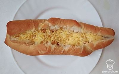 Булку для хот-дога разрежьте вдоль, не до конца. Положите в нее сосиску, предварительно снимите с нее шкуру. Сверху посыпьте сыром. Поставьте в микроволновку на 1-2 минуты, чтобы сыр расплавился и булка немного нагрелась.