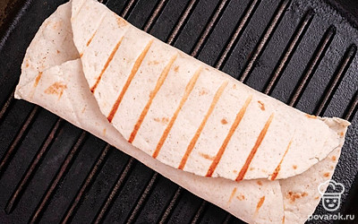Разогрейте гриль и обжарьте рулет из тортильи с каждой стороны. Сыр внутри должен расплавиться, а сама лепешка немного зарумяниться. Готово.