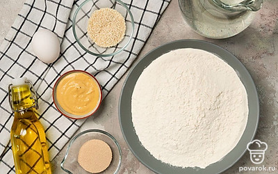 Воду для замешивания теста заранее нагрейте до теплого, но не горячего состояния. Муку предварительно просейте, чтобы разбить комочки и насытить ее кислородом. Яйцо вымойте, отделите желток и взбейте его. Укроп помойте и мелко нарежьте. Маслины нарежьте колечками. Подготовьте противень и пергамент для выпечки.