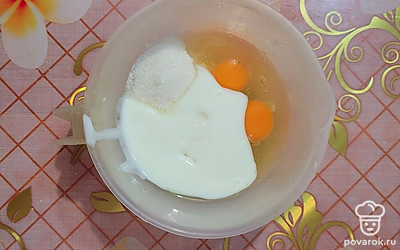 В глубокой миске смешайте кефир (он должен быть теплым), яйца, соду и сахар. 