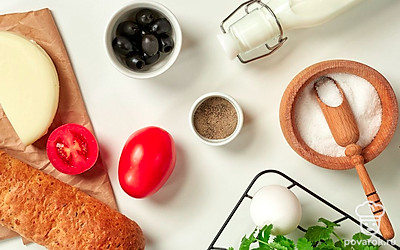 Помидоры, листья салата и кинзу вымойте, обсушите на бумажных полотенцах. Откройте баночку с маслинами, слейте жидкость.Сулугуни и помидор нарежьте пластинами. Каждый кусочек помидора разрежьте пополам. Кинзу нашинкуйте, маслины нарежьте колечками. Приготовьте жаропрочную форму. Включите духовку на 200 градусов.