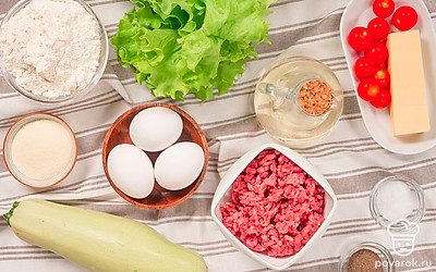 Для приготовления фаршированных кабачков с фаршем на сковороде заранее вымойте и обсушите на чистом полотенце овощи. Не забудьте тщательно вымыть куриные яйца, даже если на них нет видимых загрязнений. Это можно сделать с помощью теплой проточной воды и обычной пищевой соды. Салат латук и помидоры черри для подачи промойте и обсушите.