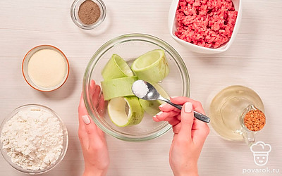 Подготовьте кабачки. Чистые кабачки нарежьте кружочками толщиной 1-1,5 см. С помощью ножа вырежьте из кружочков кабачков середину. Кабачковые кольца переложите в глубокую тарелку, засыпьте 0,5 ч. л. соли, перемешайте и оставьте на 10 минут, чтобы кабачки пустили сок.