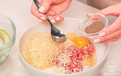 Приготовьте начинку. Натрите на мелкой терке или измельчите в блендере твердый сыр. В глубокой миске соедините фарш, сыр, 1 куриное яйцо, манку и 0,5 ч. л. соли. Добавьте черный молотый перец и перемешайте начинку.