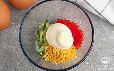 Смешайте вместе в отдельной миске огурец, сыр, майонез, красную икру и яичный желток. Посолите и поперчите получившуюся густую массу.