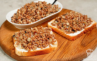 Соберите тосты. Обжарьте хлеб с двух сторон на сухой сковороде до золотистой корочки. Намажьте на кусочки хлеба тонким слоем творожный сыр, сверху выложите гречку с грибами.