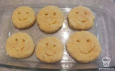 Форму для выпекания смазываем растительным маслом и выкладываем картофельные лепешки. Делаем глазки и улыбочки с помощью зубочистки. Ставим форму для выпекания в разогретую до 180 градусов духовку на 30 минут. 