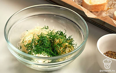 Пока ломтики багета пропитываются, займитесь начинкой. Чеснок и сыр измельчите при помощи терки с мелкими ячейками, добавьте майонез и перемешайте. Петрушку измельчите, всыпьте в майонезную смесь. Добавьте прованские травы, перемешайте.