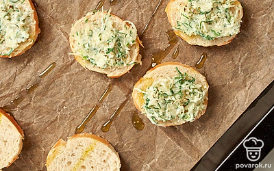 Запеките багет со специями. На кусочки хлеба намажьте полученную массу, отправьте в духовку на 4-5 минут. По истечении указанного времени переключите духовой шкаф на верхний гриль и запекайте еще 5 минут.