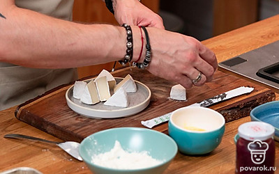 Шайбу сыра нарежьте на равные 8 треугольников. Выложите сыр на пергамент и уберите в морозилку на 10-15 минут. За это время подготовьте всё для панирования.