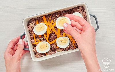 Соберите холодец. В форму положите мясо, сверху разложите морковь и яйца, залейте бульоном, полностью закрыв мясо, и уберите в холодильник на 3 часа. После застывания залейте оставшимся бульоном и снова уберите в холодильник до полного застывания на 3 часа.