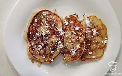 Готовые оладьи посыпьте сахарной пудрой. Их можно дополнить сметаной. 