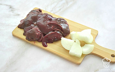 Куски куриной печени ополосните прохладной водой. Удалите прожилки и пленочки. Крупные куски разрежьте на 2 части. Лук нарежьте на ломтики.