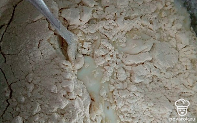 Постепенно всыпьте просеянную муку, перемешивая смесь.