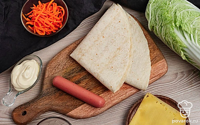 Приготовьте необходимые ингредиенты. Первые листики с капусты уберите. С сосиски снимите обертку.