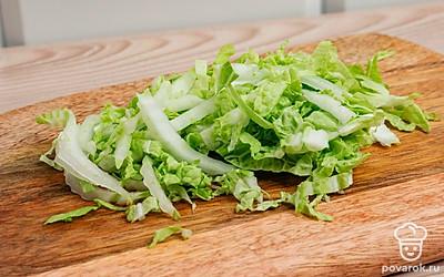 Нашинкуйте капусту. Сосиску разрежьте вдоль на 2 части.