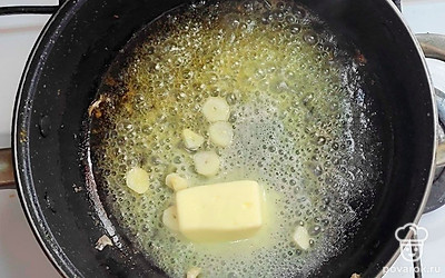 В разогретой с оливковым маслом сковороде обжарьте очищенные креветки. Креветки выложите в тарелку. В ту же сковороду, где готовились креветки, добавьте сливочное масло и чеснок, нарезанный кусочками. Немного обжарьте чеснок и уберите его из сковороды.