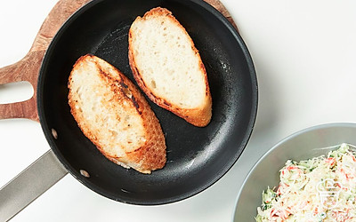 Подготовьте основу для бутербродов. Нарежьте багет на ломтики 1,5 см толщиной. Разогрейте сковороду, смажьте ее сливочным маслом. Выложите ломтики хлеба на сковороду и поджарьте их с двух сторон.